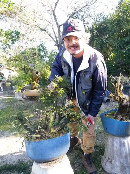 Tomio Tomita cuidando das plantas na chácara
